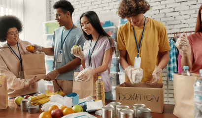 Young male and female volunteers pack food for donation.