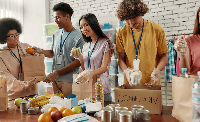 Young male and female volunteers pack food for donation.